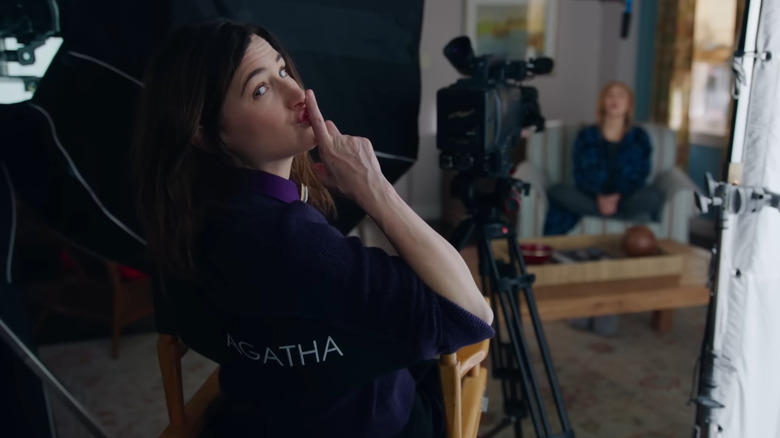 Kathryn Hahn as Agatha Harkness, sitting in a director's chair in WandaVision.