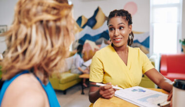 This is an image of two women meeting at a table and reviewing graphs/charts.