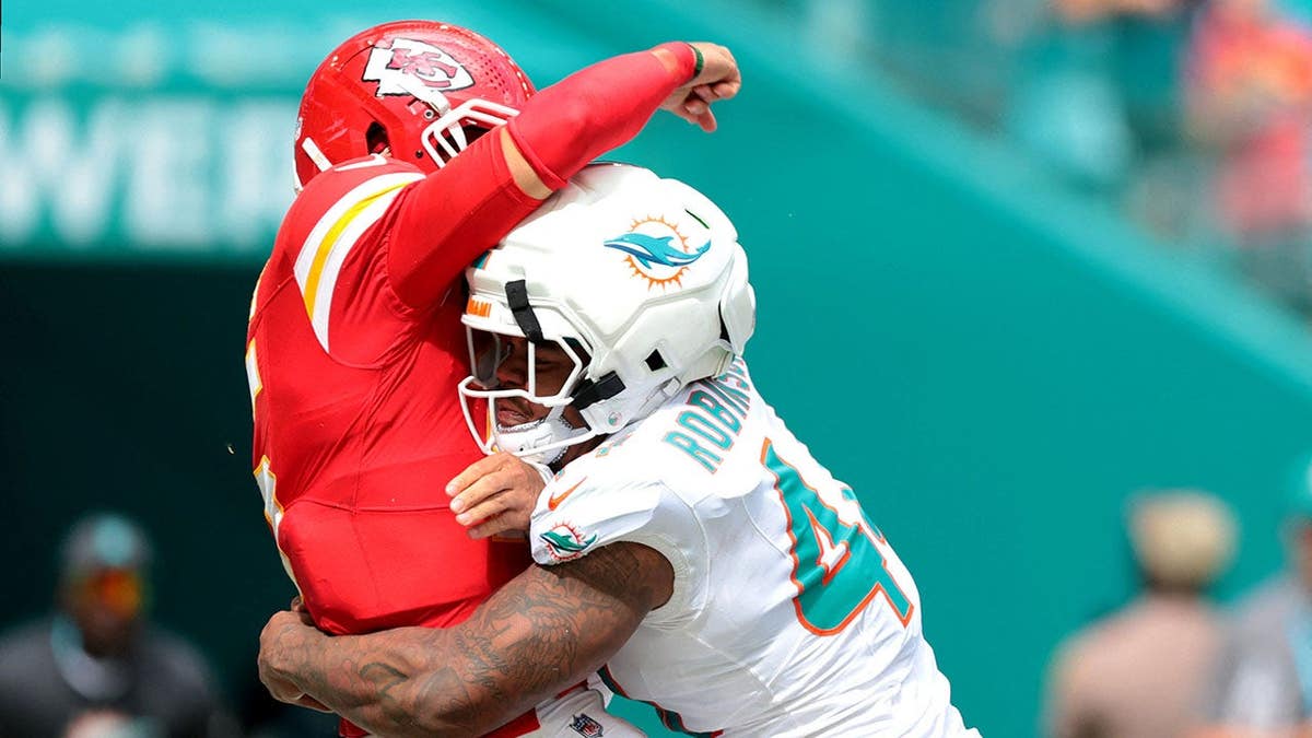 Chop Robinson, Miami Dolphins defensive end, hits Kansas City Chiefs quarterback Patrick Mahomes during an NFL game.