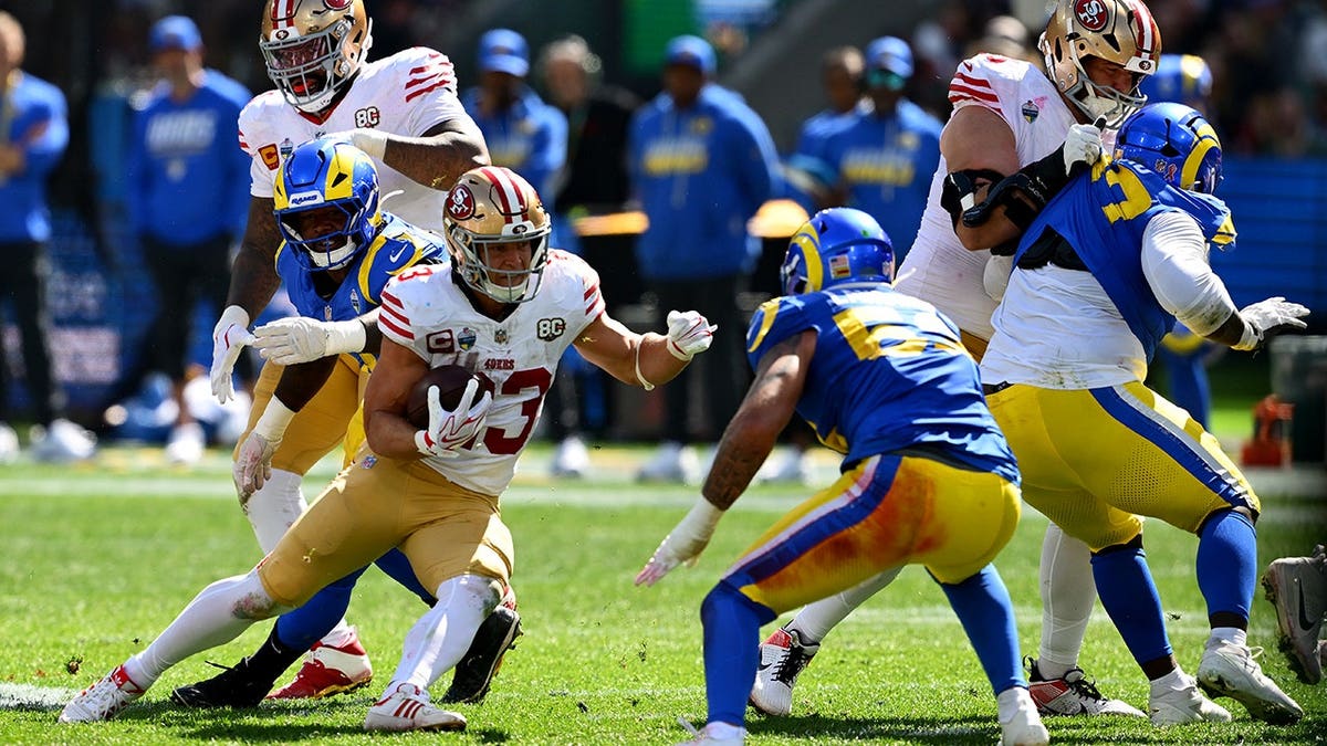 Christian McCaffrey runs with the ball during an NFL game at Melbourne Cricket Ground.