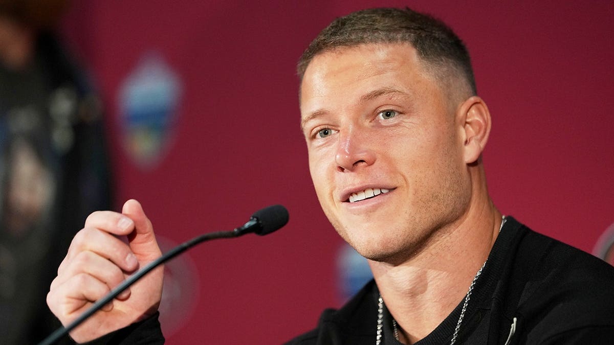Christian McCaffrey speaks at a news conference after an NFL game.