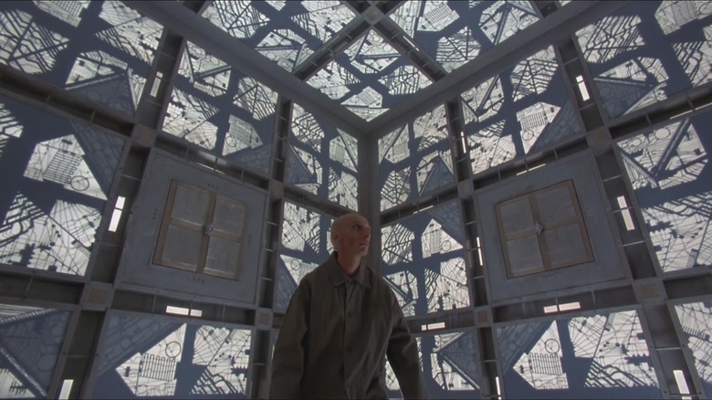A prisoner looking scared in a weird cubic cell in Cube