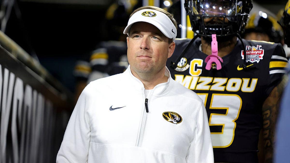 Eli Drinkwitz of Missouri Tigers stands in stadium tunnel before game.