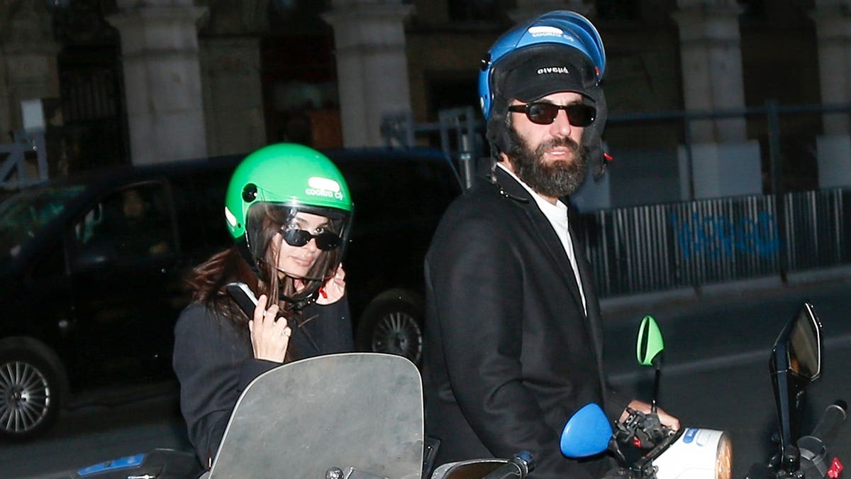 Emily Ratajkowski and Romain Gavras walk together outdoors in Paris.