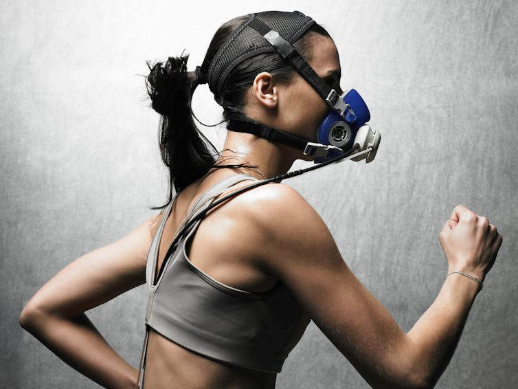 A woman wearing sensors and breathing mask running