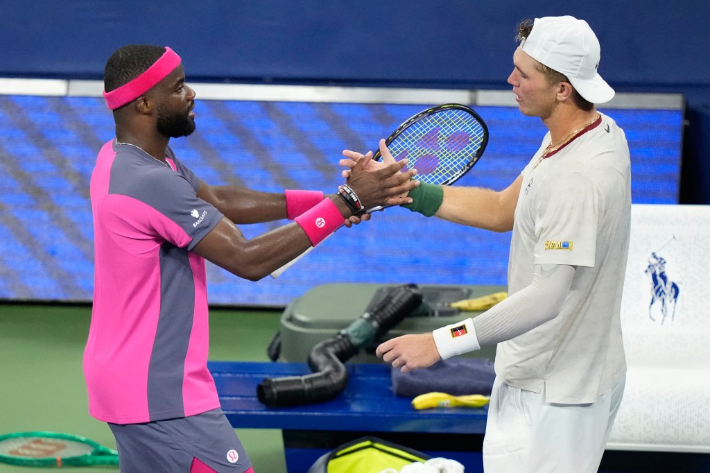 Frances Tiafoe and Martin Damm embrace on the tennis court.