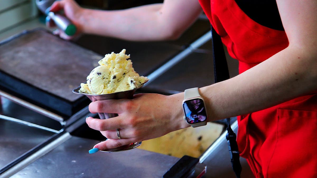 A Friendly's employee scoops ice cream.
