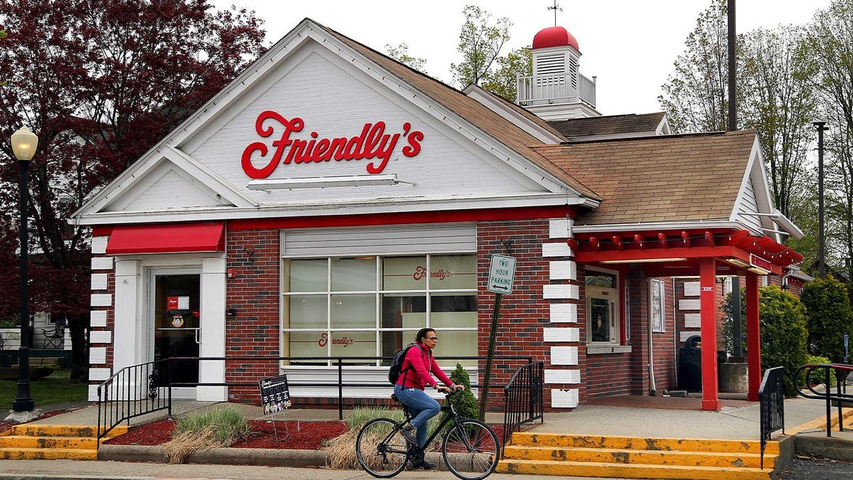 A bicyclist rides by a Friendly's restaurant.