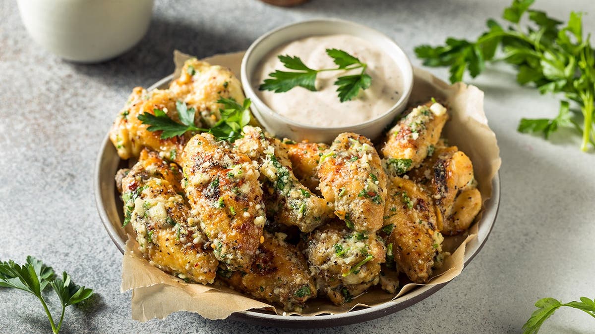 A plate of garlic wings sits on a plate.