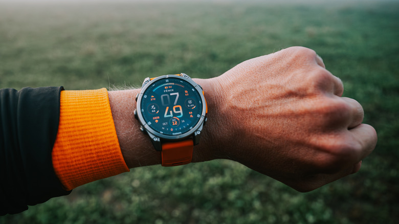 A Garmin Fenix 8 on a wrist outside in nature