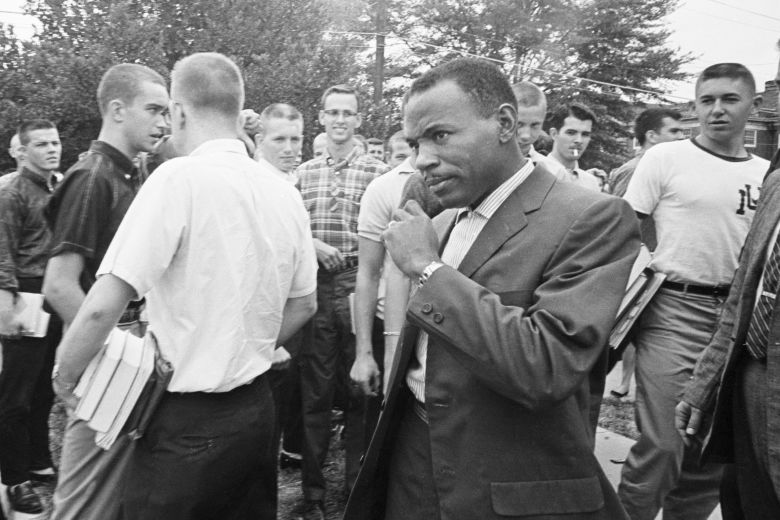James Meredith walks across the University of Mississippi campus after class amid the stares and jeers of fellow students. Meredith was the first African American student at