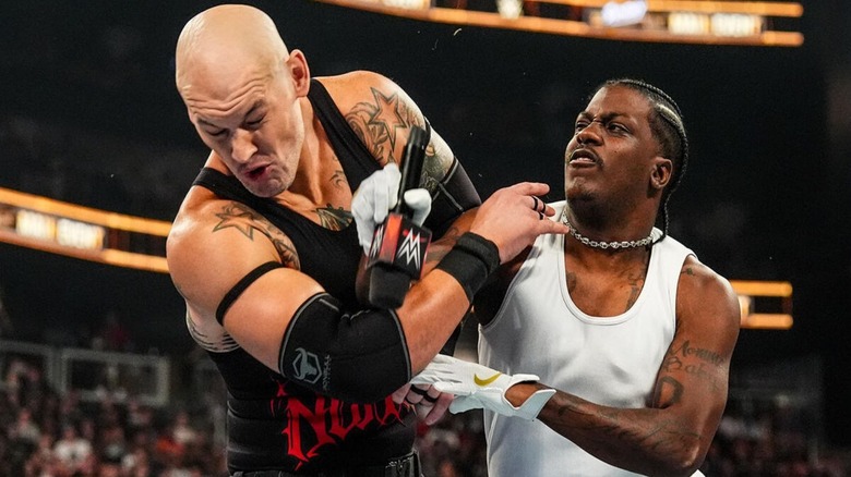 Rapper and WWE talent Lil Yachty hits Baron Corbin with a microphone in the ring ahead of their match at Sunday Night's Main Event in September 2026.