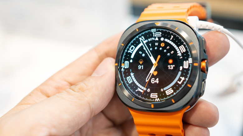 A Samsung Galaxy Watch with an orange band