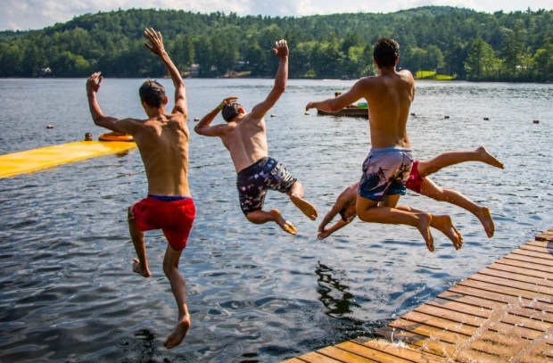 Campers jump into a lake during a device-free camp in Maine. (Maine Teen Camp)