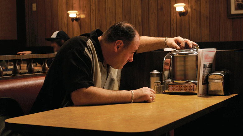 James Gandolfini as Tony Soprano, flipping through a table jukebox in The Sopranos.