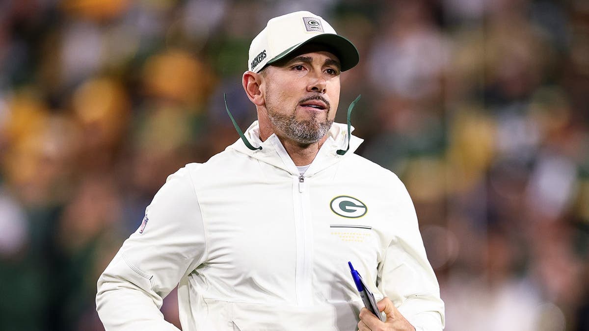 Matt LaFleur runs onto the field before a game at Lambeau Field.