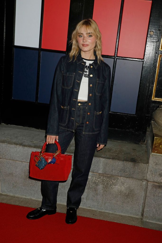 Meg Donnelly in a denim outfit with a red handbag at the Tommy Hilfiger show for Spring/Summer 2027.