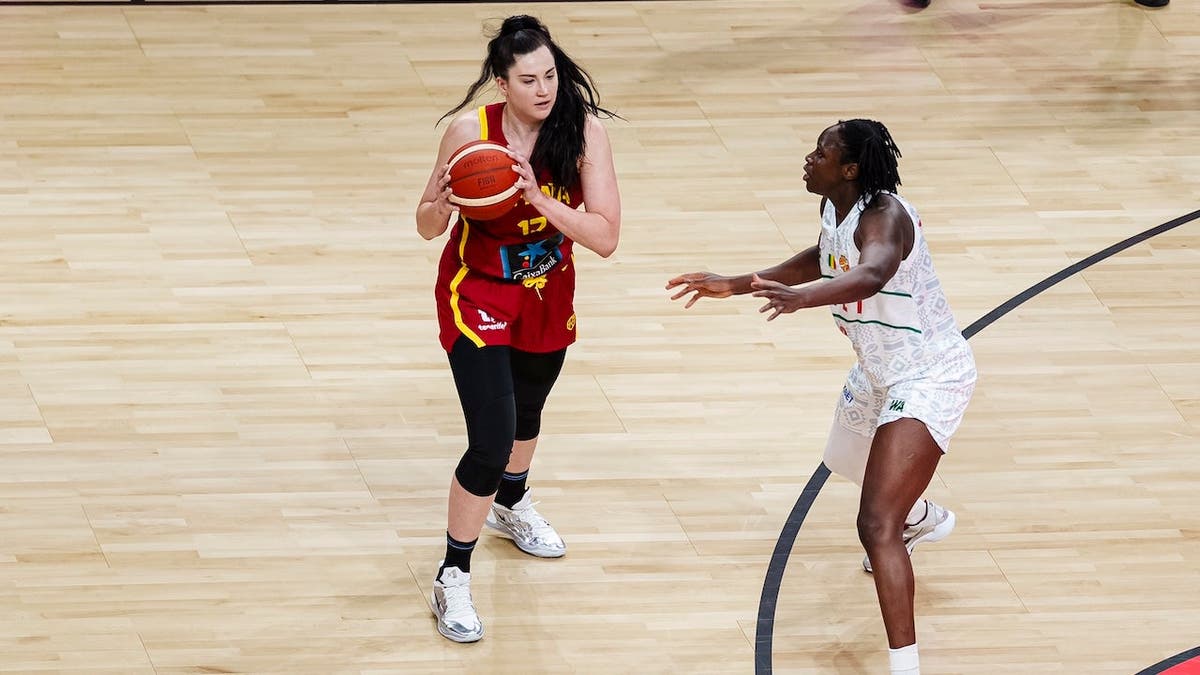 Megan DiLeo of Spain looks to pass the ball during a basketball game.