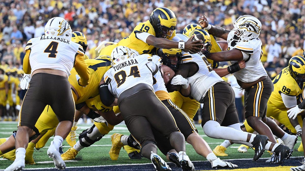 Michigan quarterback Bryce Underwood (19) stretches the ball over the goal line