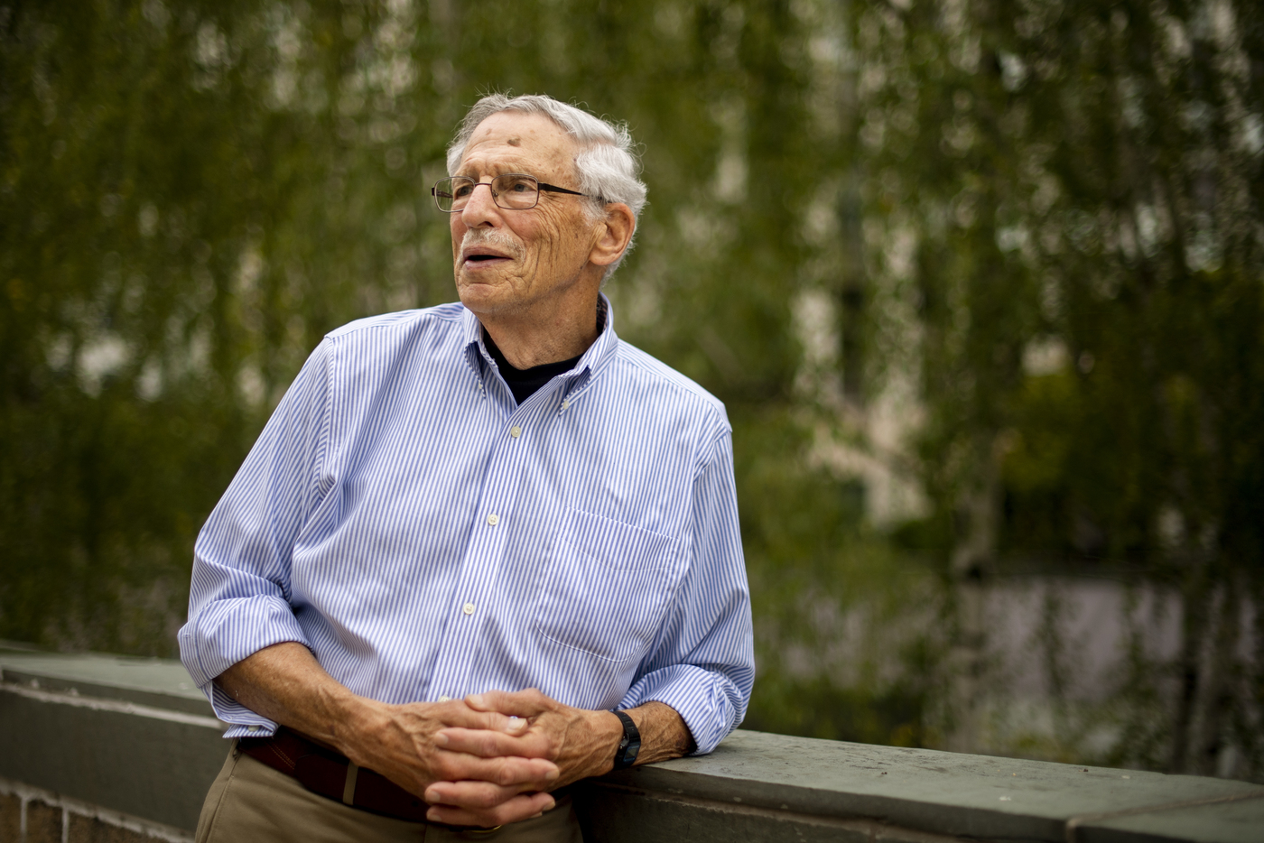 Michael Meltsner leaning on a railing outdoors, looking off to the side.