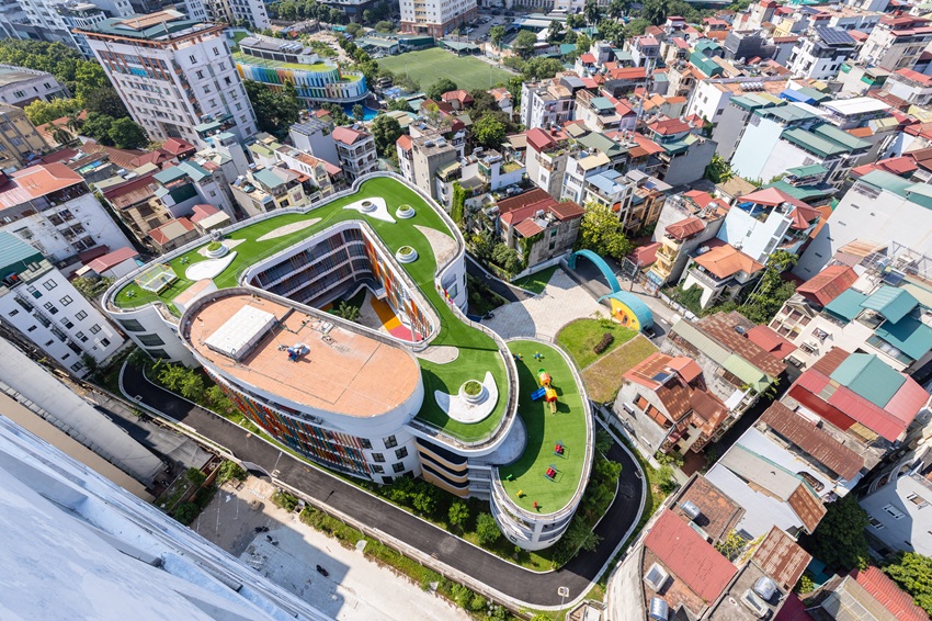 elliptical classroom volumes and colorful louvers shape courtyard kindergarten in hanoi - 1