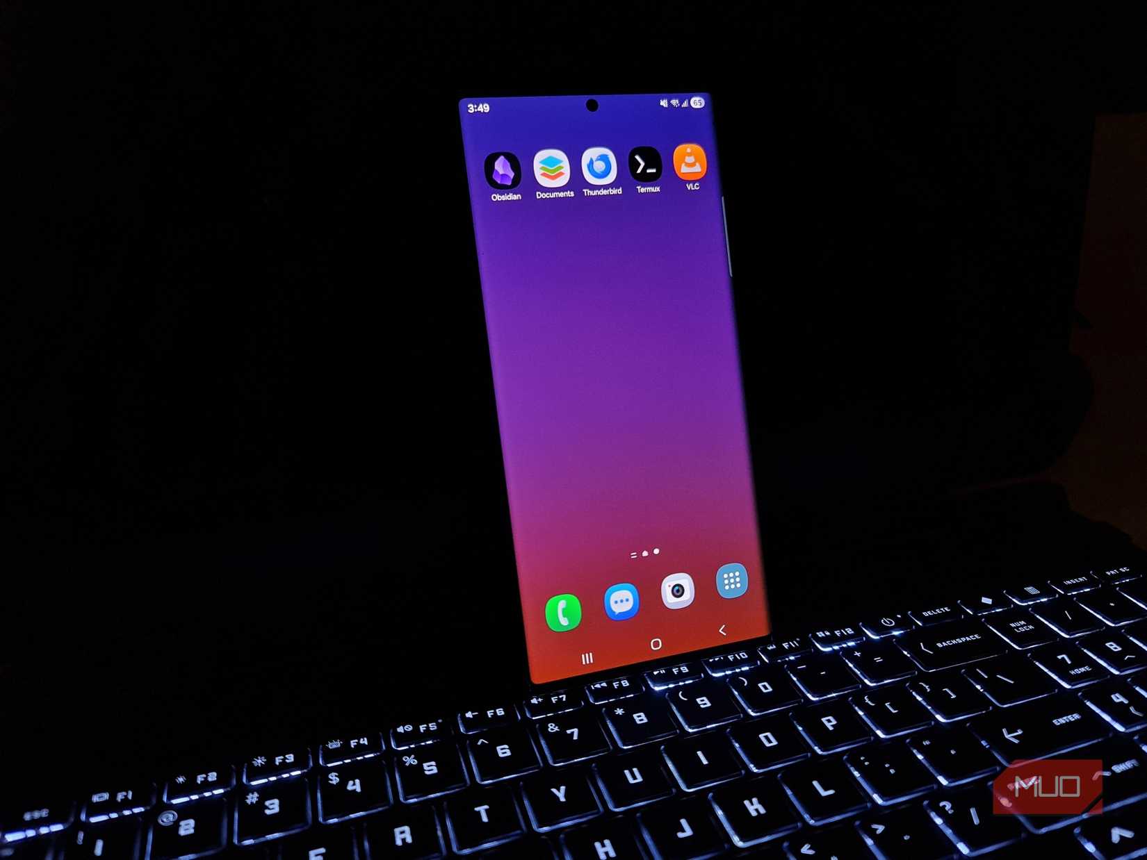 Samsung Galaxy Note20 Ultra displaying the five tested Android apps alongside a blank laptop display