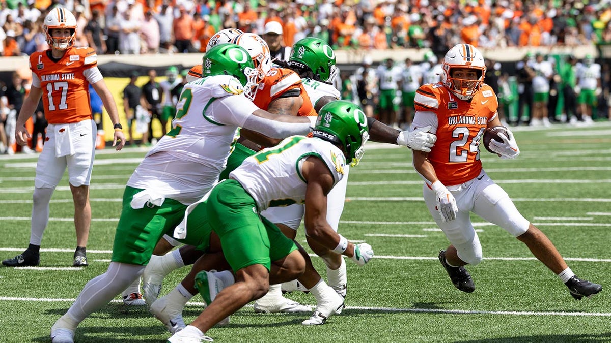 Oklahoma State running back Caleb Hawkins (24) runs the ball in the first half of the NCAA college football game against Oregon in Stillwater, Okla., Saturday, Sept. 12, 2026.