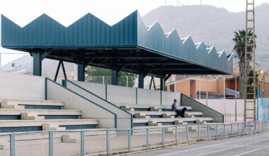 lime-green gateway and blue solar canopy reform sports center in spain
