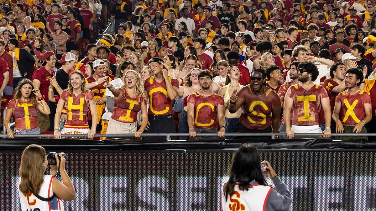 USC Trojan football fans cheer in the stands at Los Angeles Memorial Coliseum.