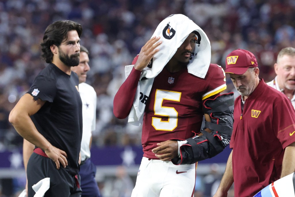 Washington Commanders quarterback Jayden Daniels (5) leaves the game with an apparent injury to his left arm during the second half against the Dallas Cowboys at AT&T Stadium in Arlington, Texas, Sunday, September 20, 2026.