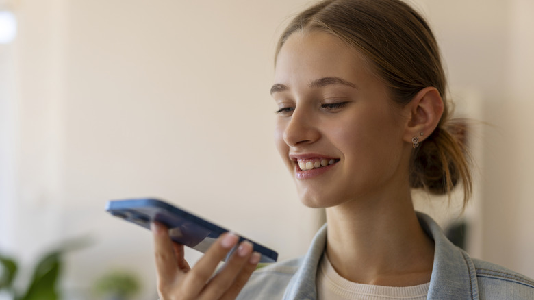 young woman talking to siri on iphone