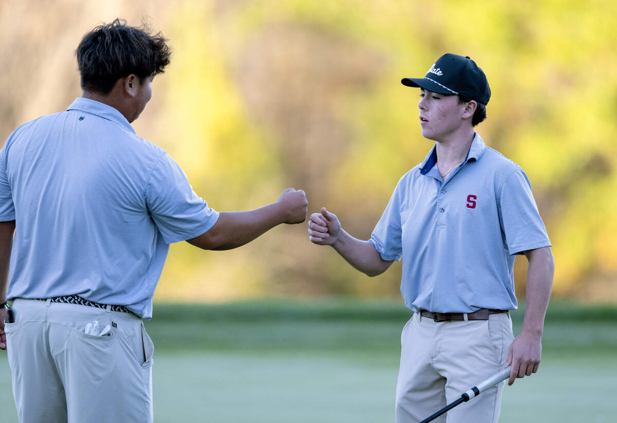State College’s Jacky Sun and Luke Ladrido fist bump after the second hole of the playoff for the PIAA Golf Team Championships on Wednesday, Oct. 21, 2026 at the Penn State Golf Course.