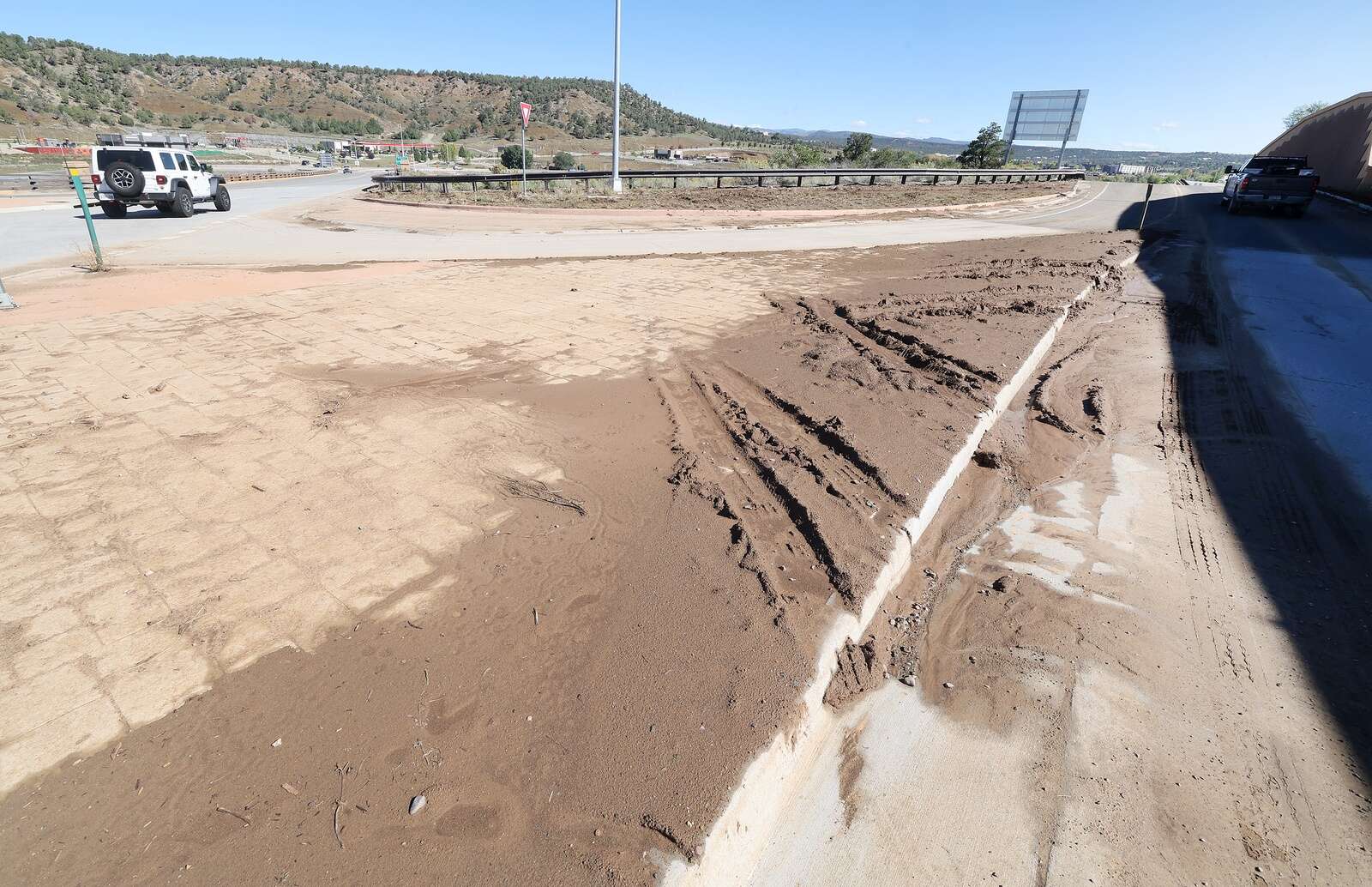 Mud covers the island and part of the road by the south roundabout on Wednesday on U.S. Highway 550 in the Grandview area. (Jerry McBride/Durango Herald)