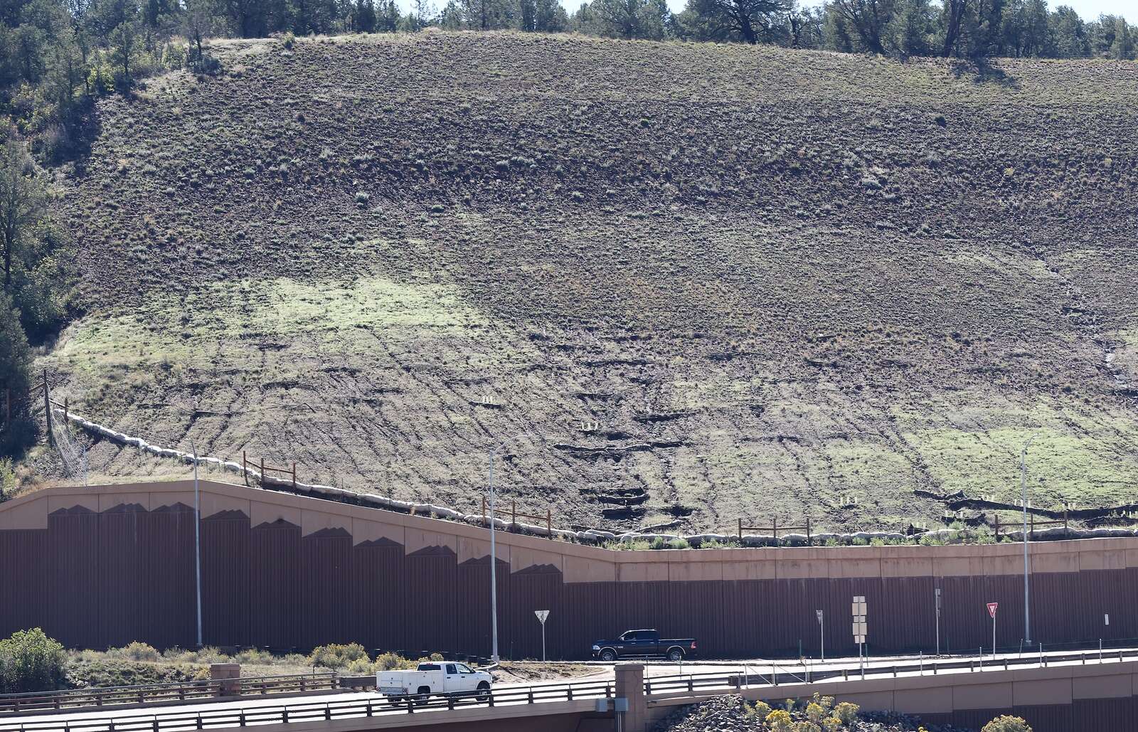 Erosion from this hillside covers the island and part of the road with mud above the south roundabout Wednesday on U.S. Highway 550 in the Grandview area. (Jerry McBride/Durango Herald)