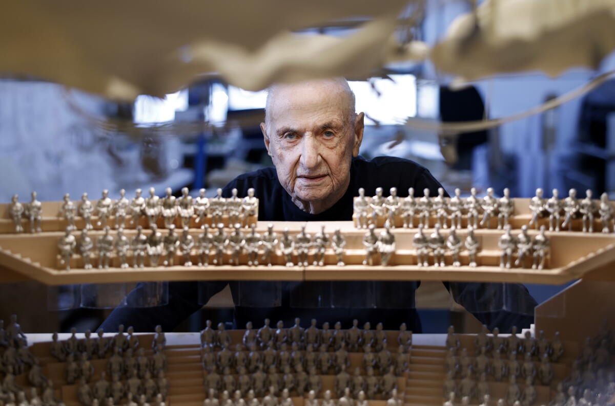 Frank Gehry looks at a model.