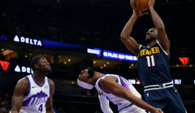 Denver Nuggets forward Alpha Diallo, right, drives to the basket and fouls Utah Jazz guard Josh Okogie, center, during the second half of an NBA basketball game, Tuesday, Oct. 6, 2026, in Salt Lake City. (AP Photo/Tyler Tate)