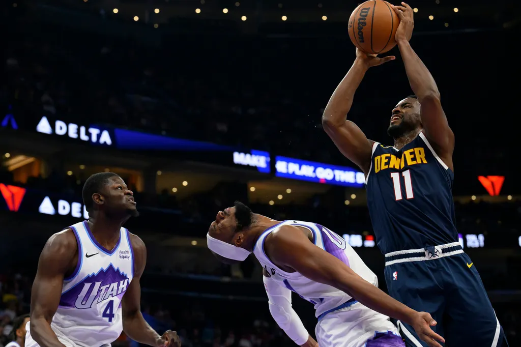 Denver Nuggets forward Alpha Diallo, right, drives to the basket and fouls Utah Jazz guard Josh Okogie, center, during the second half of an NBA basketball game, Tuesday, Oct. 6, 2026, in Salt Lake City. (AP Photo/Tyler Tate)