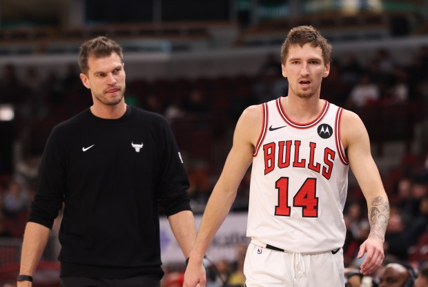 Bulls forward Matas Buzelis heads to the bench ahead of coach Tiago Splitter in the first quarter of a preseason game against the Grizzlies on Oct. 9, 2026, at the United Center. (John J. Kim/Chicago Tribune)