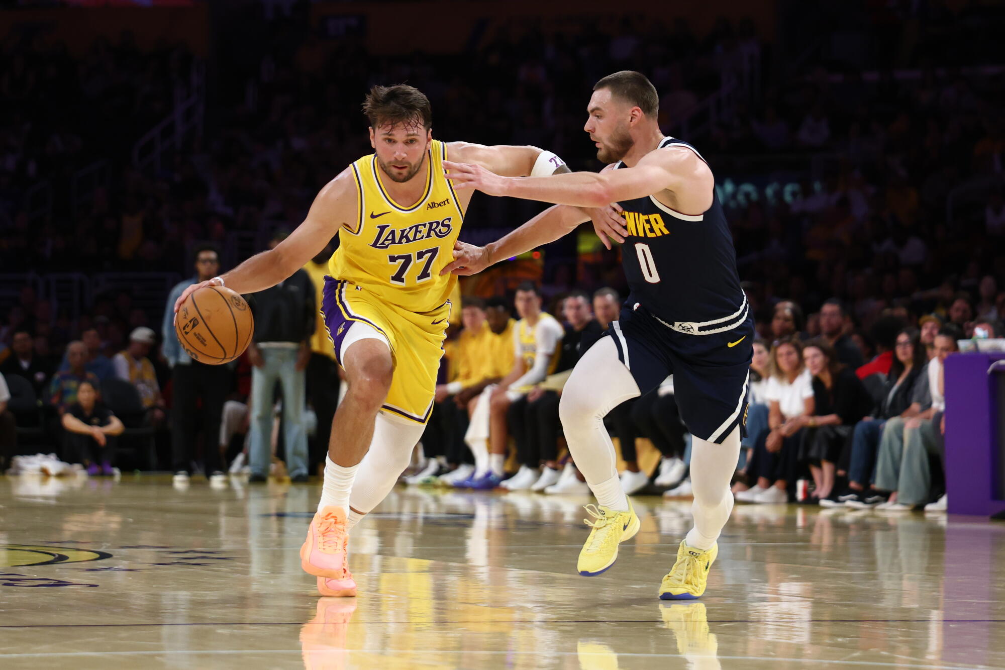 Lakers guard Luka Doncic, left, bring the ball upcourt under pressure from Nuggets guard Christian Braun.