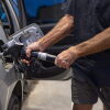 A man pumps gas at a gas station.