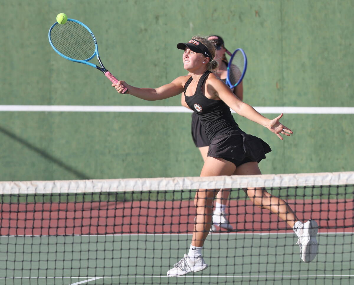 Doubles player Bella Applehof of Huntington Beach hits a winning volley with partner Carlie Ball against Newport Harbor.