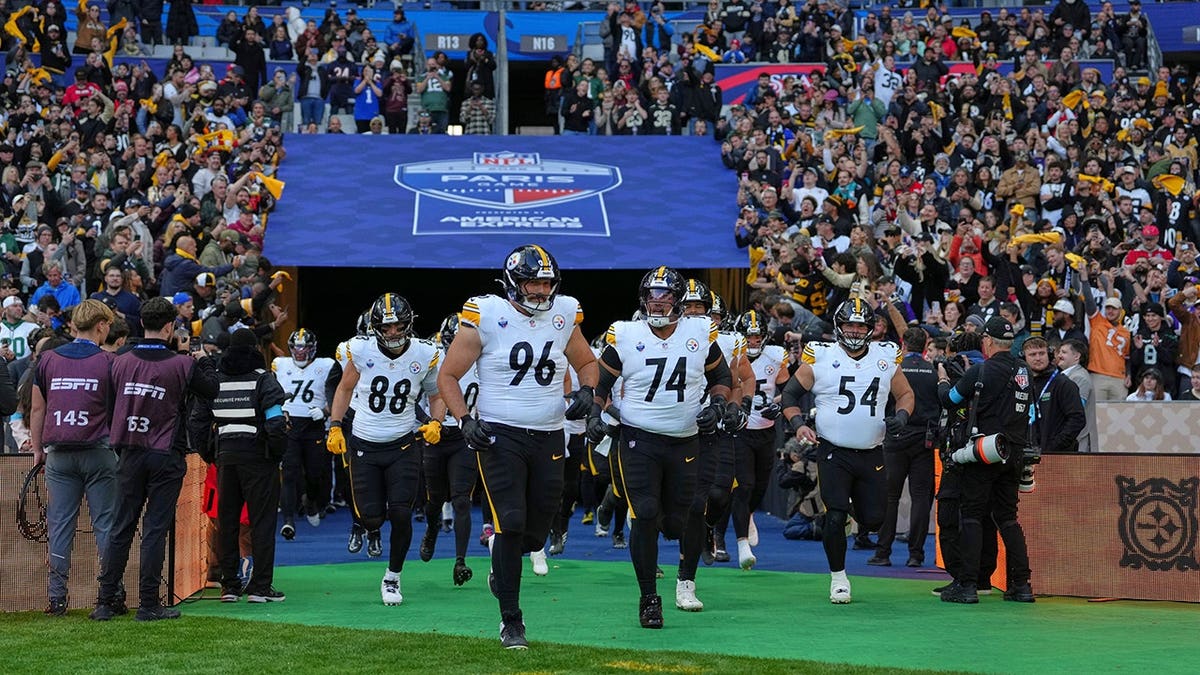 Pittsburgh Steelers players run onto the field before an NFL game against the New Orleans Saints in Saint-Denis, outside Paris.