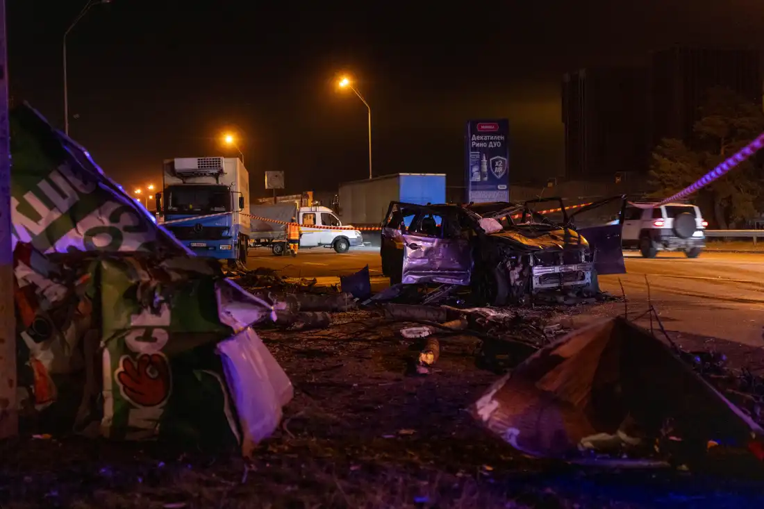 Emergency workers clear debris and damaged road infrastructure near a destroyed car following a Russian overnight strike in Kyiv, Ukraine, Tuesday, Oct. 27, 2026.