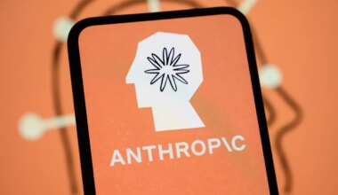 The Anthropic logo is displayed on the screen of a smartphone with the company's branding in the background.