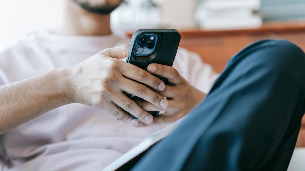 A man scrolling on his iPhone