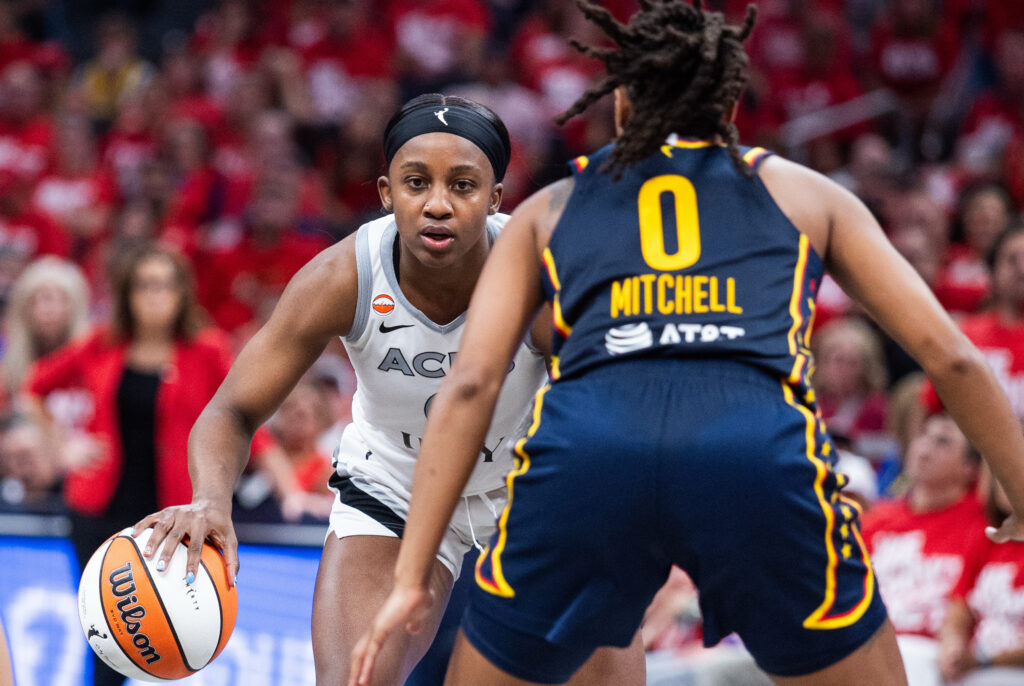 Las Vegas Aces guard Jackie Young (0) dribbles the ball while Indiana Fever guard Kelsey Mitchell (0) defends during game two of the first round for the 2026 WNBA Playoffs at Gainbridge Fieldhouse.