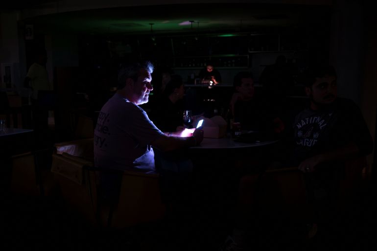 People relax in a hotel lobby during a power outage ahead of the arrival of Hurricane Isaias, in Pensacola, Florida, US, October 9, 2026. REUTERS/Marco Bello