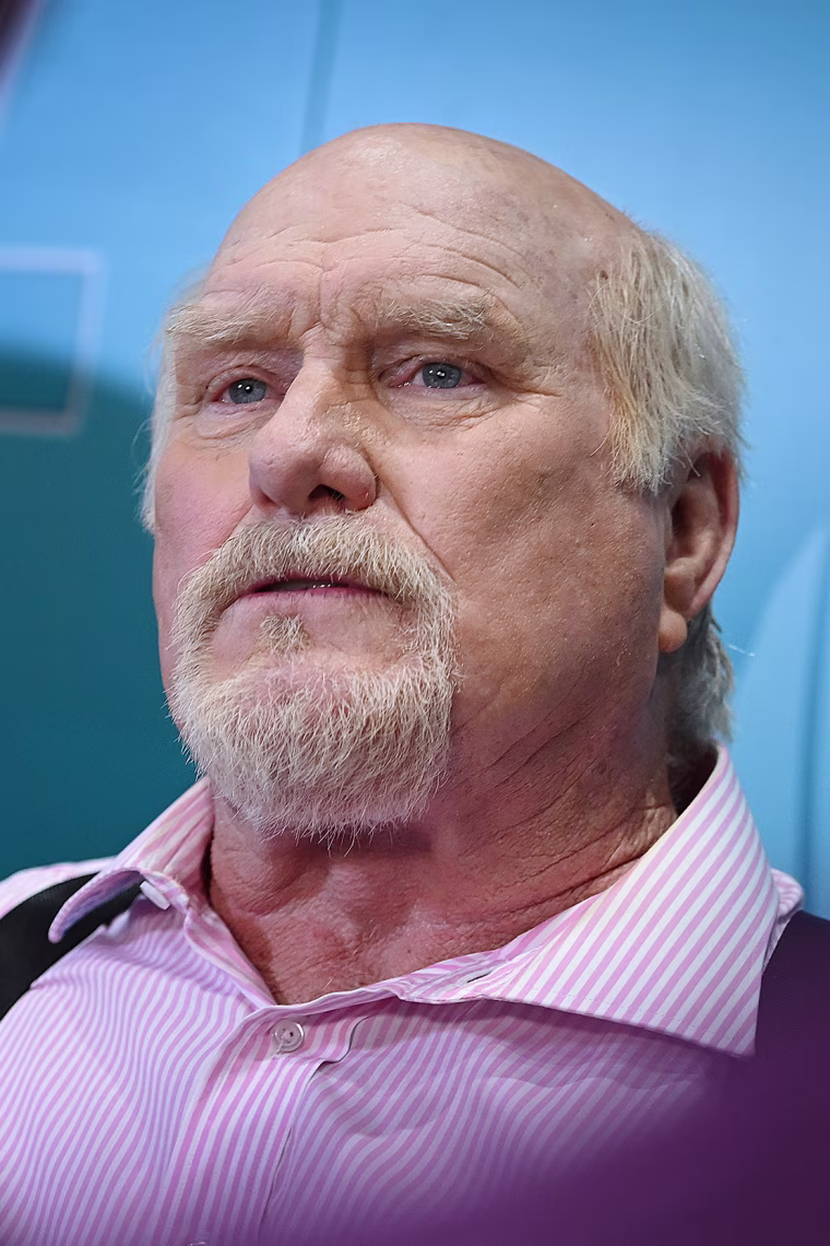 Terry Bradshaw seated in front of a blue backdrop.