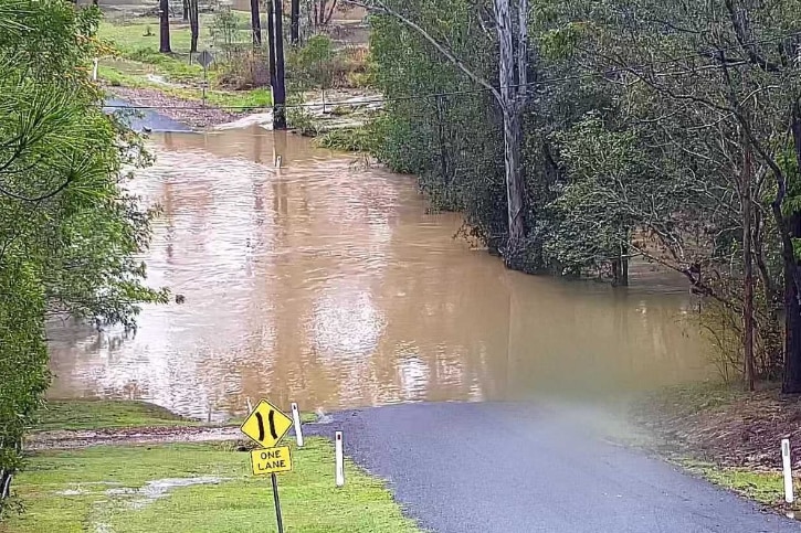a road that has brown floodwater over the top of it