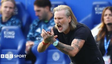 Robbie Savage, wearing a dark T-shirt, claps and shouts at his Peterborough players from the touchline
